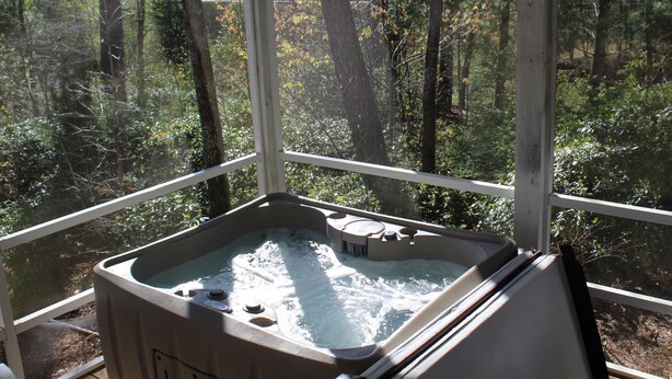 Un jacuzzi en una habitación con vistas a un bosque.