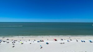 Une plage où l’on peut se détendre au soleil et se baigner, un ciel dégagé et une mer calme.