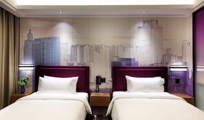 Ein Hotelzimmer mit zwei Betten, einem Stadtbild-Wandgemälde und einem Nachttisch zwischen den Betten.