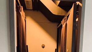 A narrow hallway with wooden steps leading to a door. - DAN Hostel (Taipei)