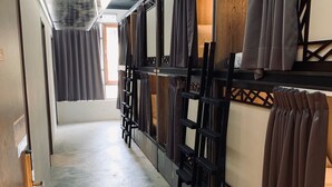 A corridor with bunk beds, wooden flooring, and a ceiling with exposed ductwork. - DAN Hostel (Taipei)