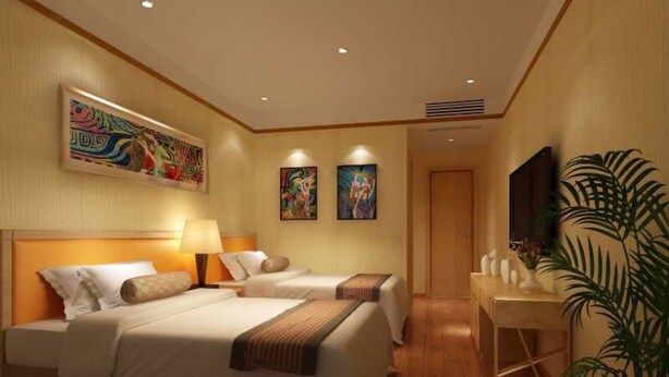 Ein Hotelzimmer mit zwei Betten, einem Schreibtisch, einer großen Pflanze und Kunstwerken an den Wänden.