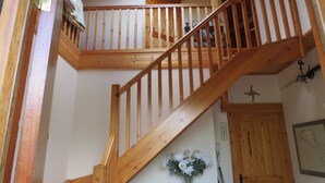 A wooden staircase with a railing leading to an upper floor. - Lakeside Country Cottage. 
 (Headford)
