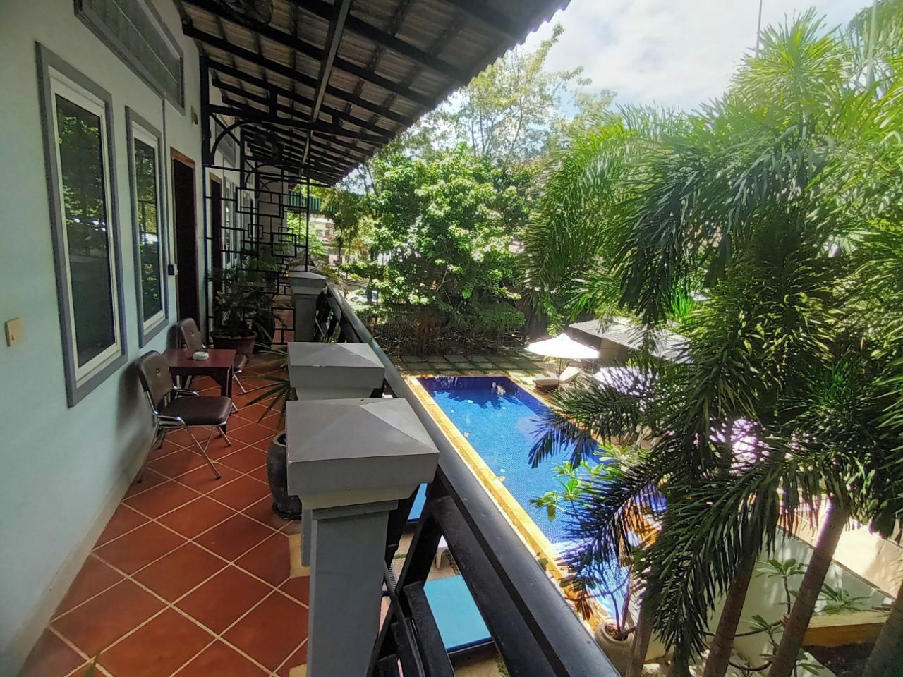 A balcony with a pool, chairs, and a table.