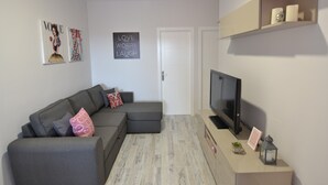 A modern living room with a grey sectional sofa, a flat-screen TV, and a minimalist design. - Beautiful new house, with terrace / solarium in Arona (Arona)