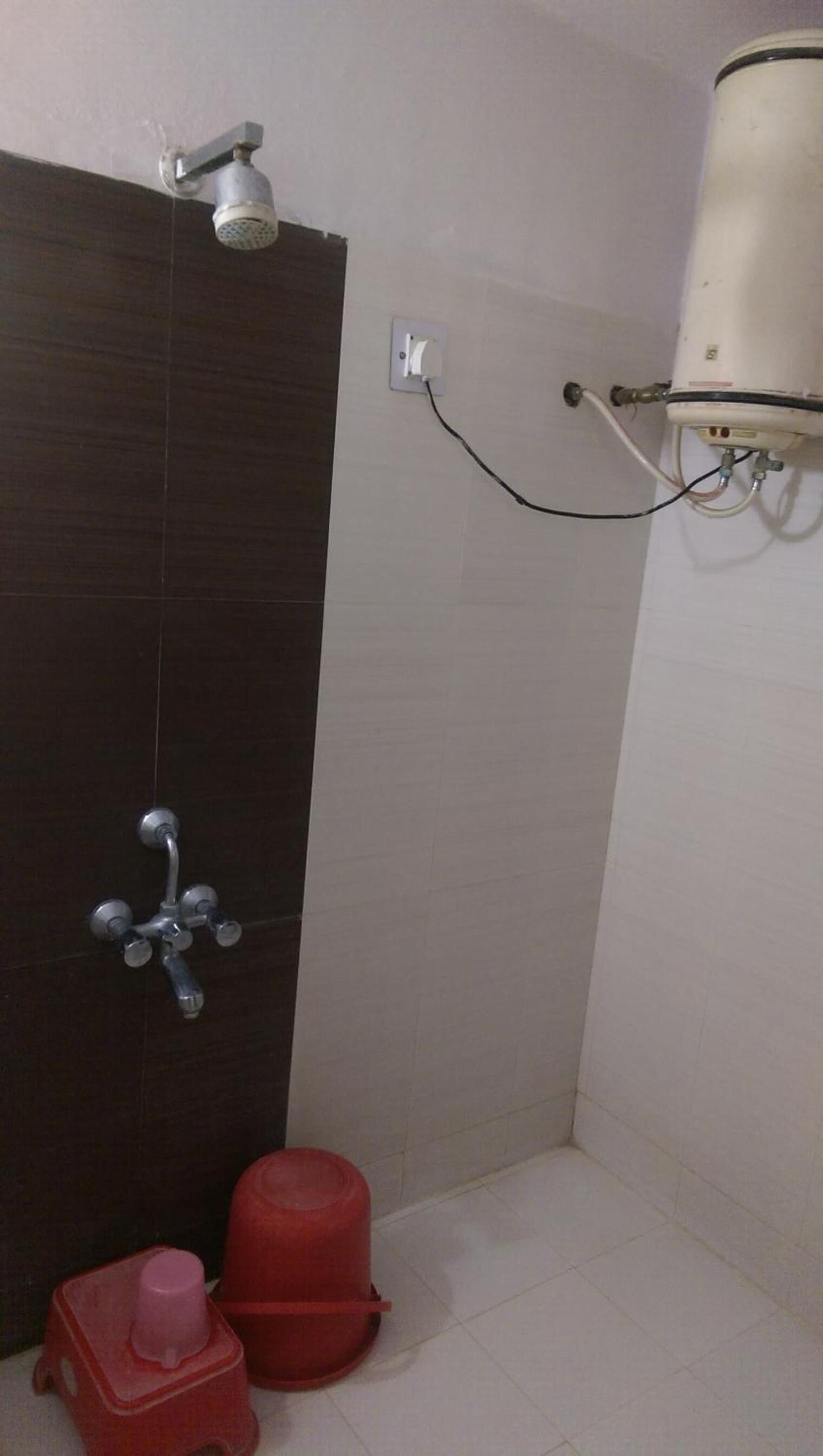 A bathroom with a shower, a toilet, and a water heater.