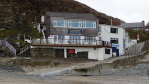 Een gebouw aan de kust met een bord waarop staat: 'SCHOONERS Gerechtificeerd Bistro Restaurant'.