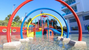 A water play area with colorful slides and climbing structures, surrounded by a clear water pool. - My Resort Huahin by Love Huahin (Hua Hin)