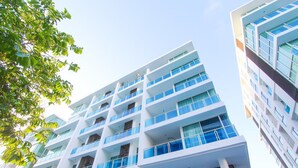 A multi-story hotel with a modern architectural design, featuring balconies on each floor. - My Resort Huahin by Love Huahin (Hua Hin)