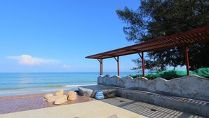 A beachside patio with a pergola, seating, and a view of the ocean. - My Resort Huahin by Love Huahin (Hua Hin)