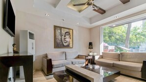 A modern living room with a sofa, coffee table, and a ceiling fan. -  The Grand Vikalp by Saga Hotels (New Delhi)