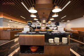 Una cocina moderna con una isla central, iluminación colgante y una variedad de utensilios de cocina.