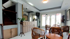 A restaurant with wooden furniture, a counter, and a television. - Hotel Bugis Asri (Yogyakarta)