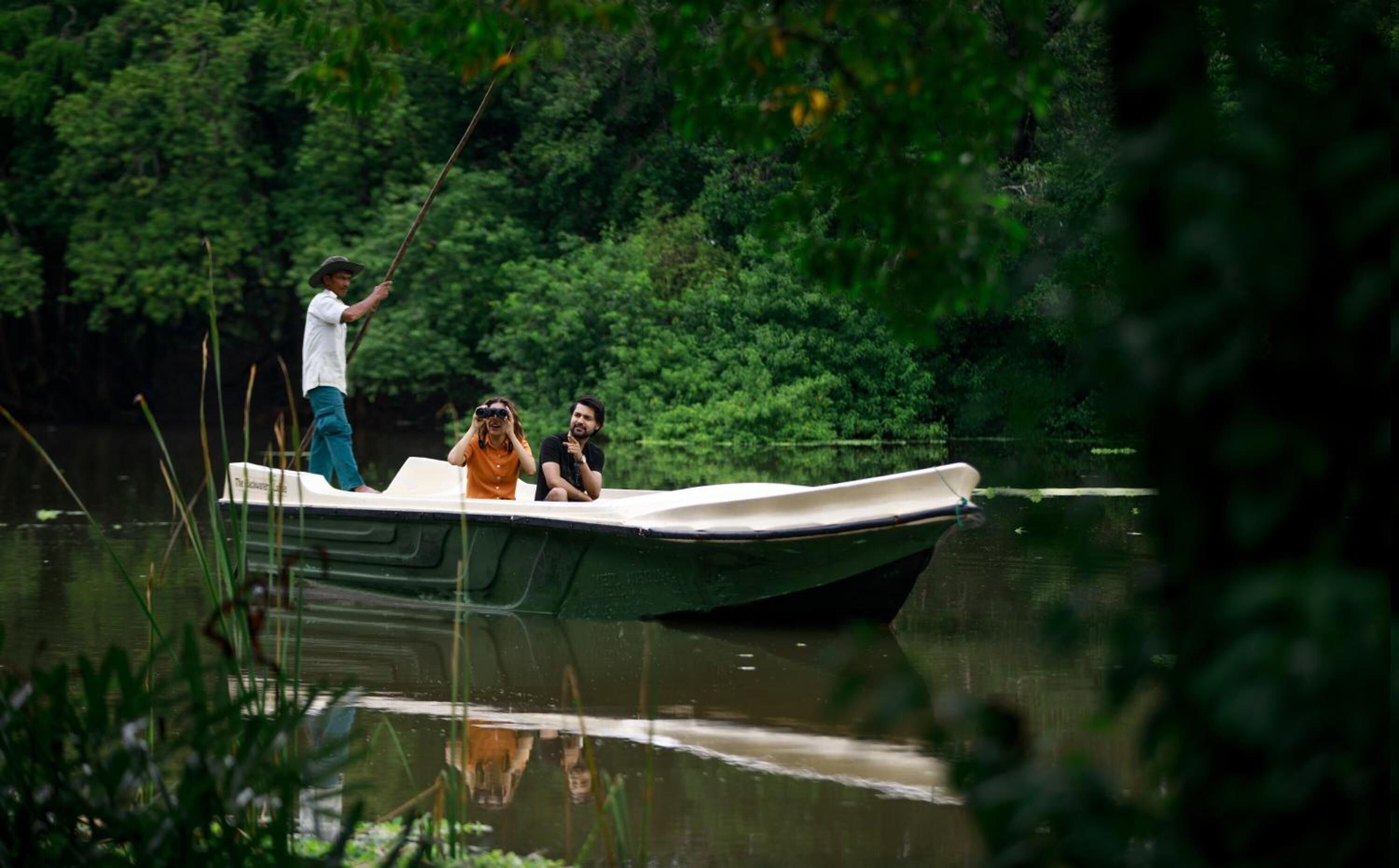 Ein kleines Boot auf ruhigem Wasser, umgeben von dichtem Grün.