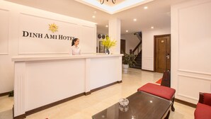 A reception desk with a sign reading "Dinh Ami Hotel," a chandelier, a potted plant, and a staircase in the background. - Dinh Ami Hanoi Hotel (Hanoi)