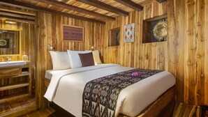 A wooden room with a bed, a wooden bench, a sink, and a mirror. - Plataran Phinisi Felicia (Labuan Bajo)