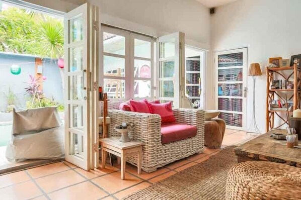 Relax in this inviting living area with a wicker sofa, side table, and comfortable chair.