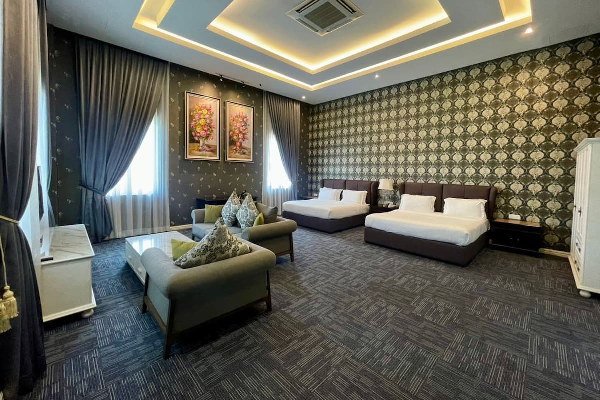 A hotel room with a bed, sofa, and a desk.