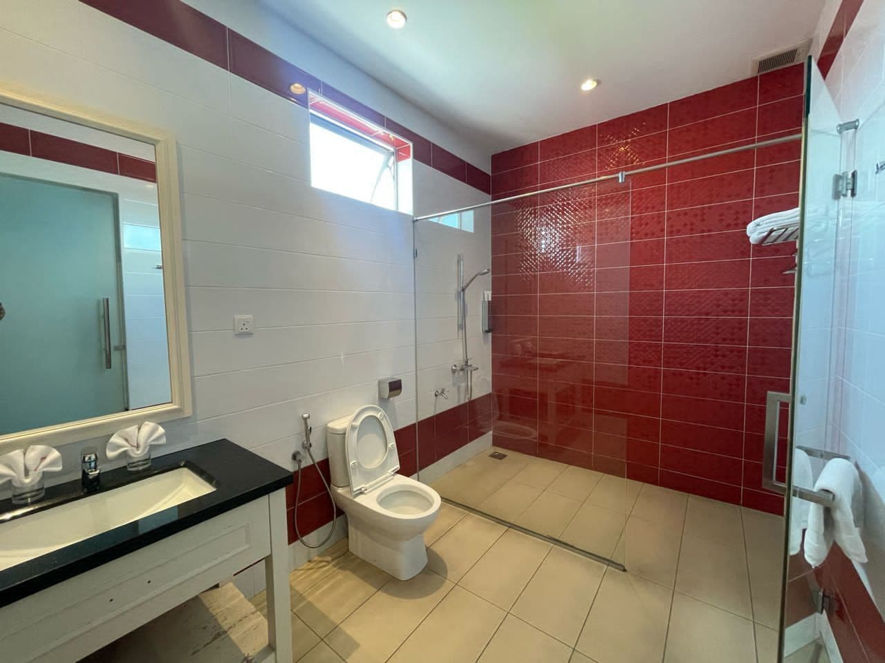 A bathroom with a white sink, a toilet, and a glass shower enclosure.