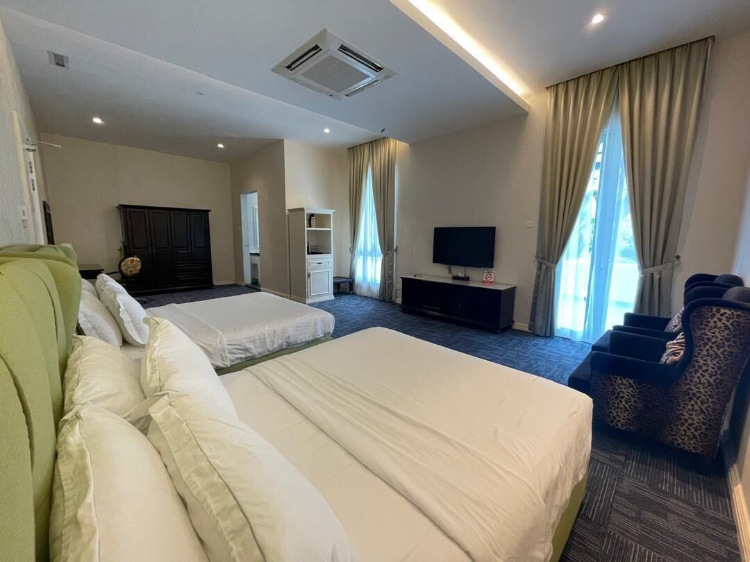 Habitación de hotel con dos camas, televisión, armario y escritorio.