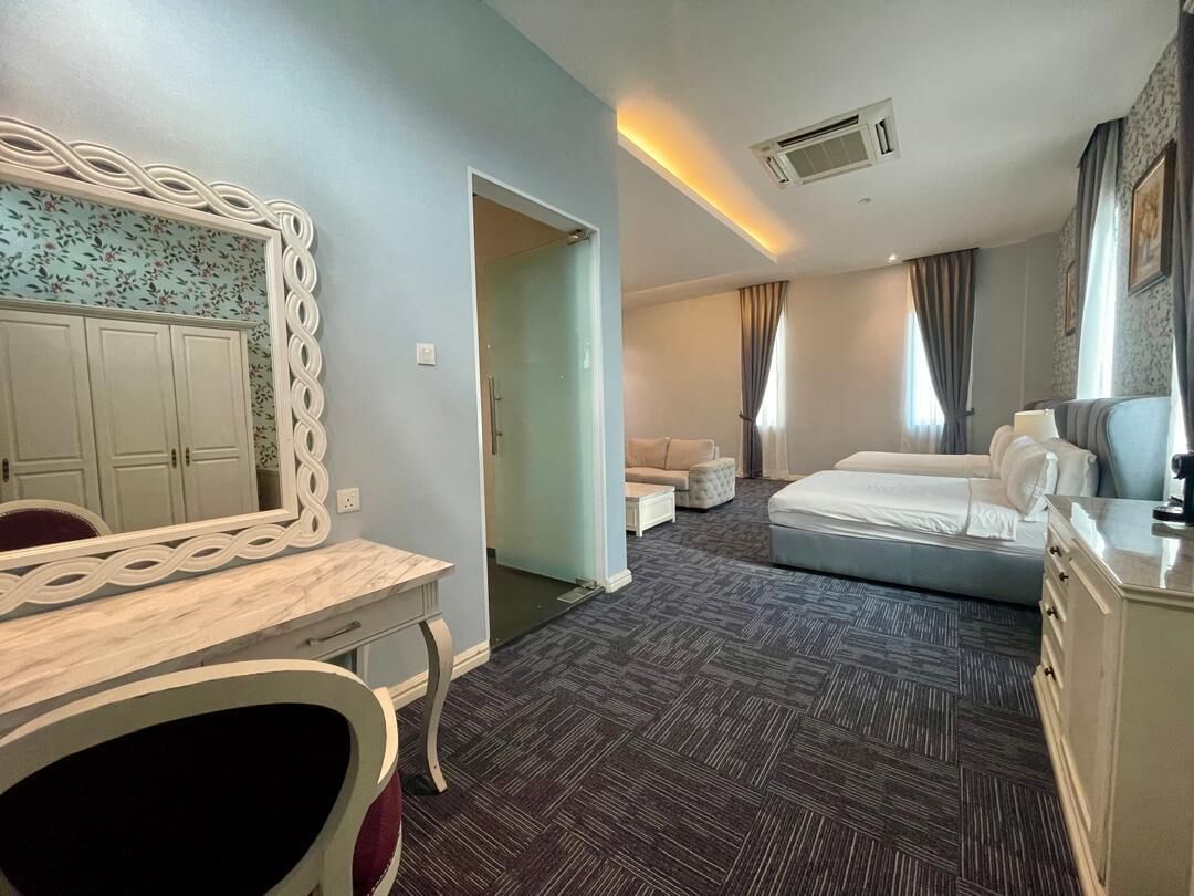 A hotel room with a bed, a desk, a chair, a wardrobe, and a bathroom.