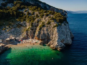 A coastal area with rocky cliffs, clear turquoise water, and a sandy beach. - Apartment with XXL terrace and infinity pool !!! (Brsec)