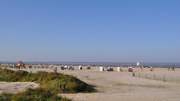 En strand med tält och en lekplats.
