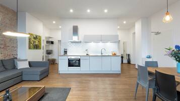 Una cocina moderna con armarios blancos, horno empotrado y una isla central.