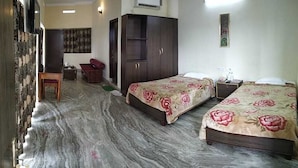 A room with two beds, a wardrobe, a desk, and a chair.