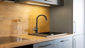 Eine Küche mit Holztischplatte, einem modernen Wasserhahn und einer Edelstahl-Spüle.