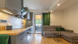 Eine moderne Küche mit Holzarbeitsplatte, integrierten Geräten und Blick auf einen Balkon.