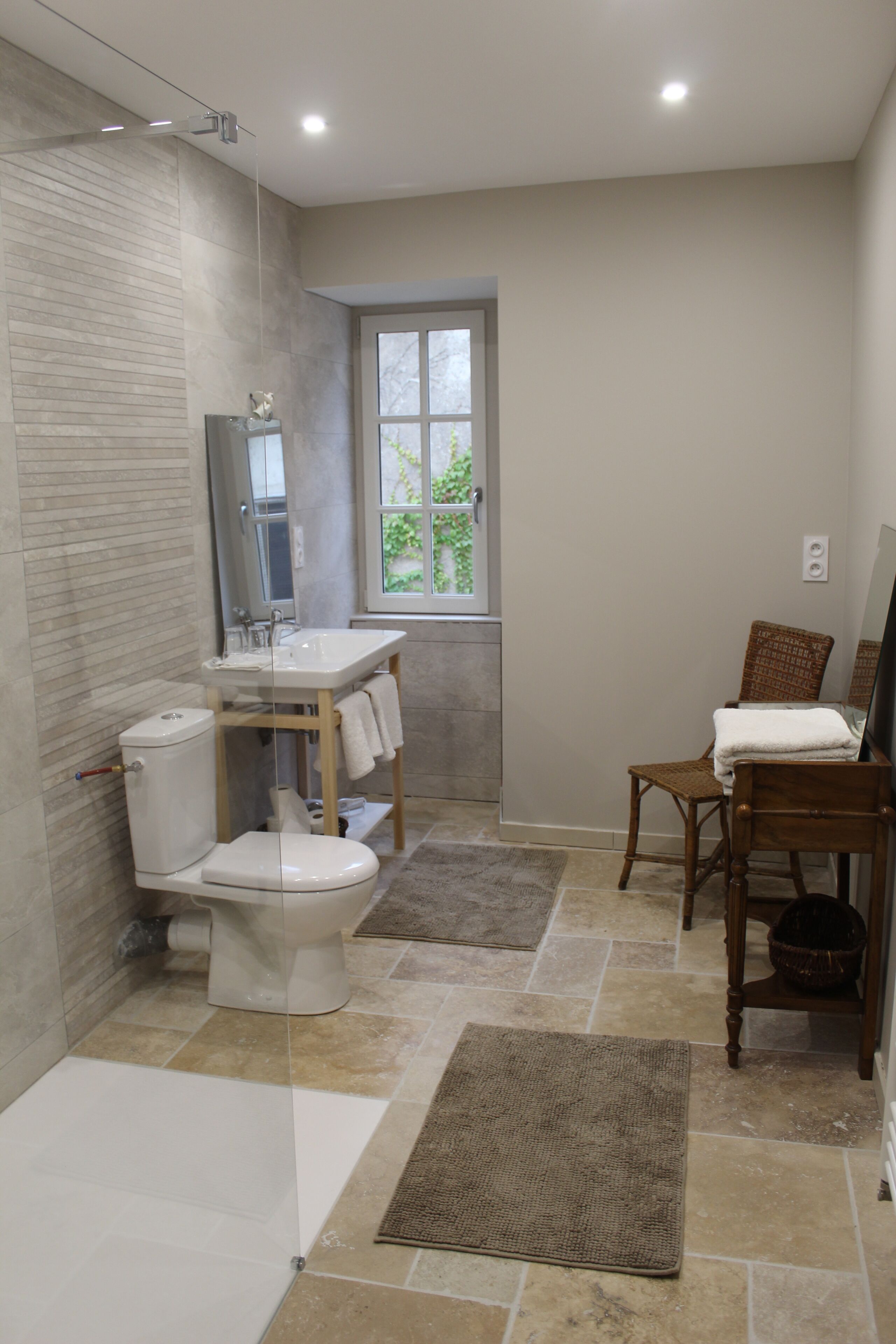 A modern bathroom with a toilet, sink, and shower.