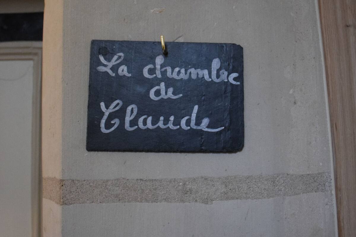 A chalkboard sign on a wall with the text "La chambre de Claude".