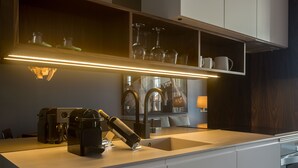 Una cocina moderna con cafetera integrada, un lavabo y una estantería para vinos.