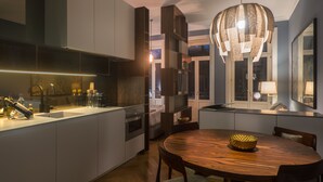 Una cocina moderna con una isla central, armarios empotrados y una mesa de madera redonda con sillas.