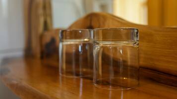 Two clear glasses on a wooden surface.