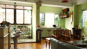 A spacious room with a dining area, a sofa, and a bar area. - Yangon Heart Guest House (Yangon)