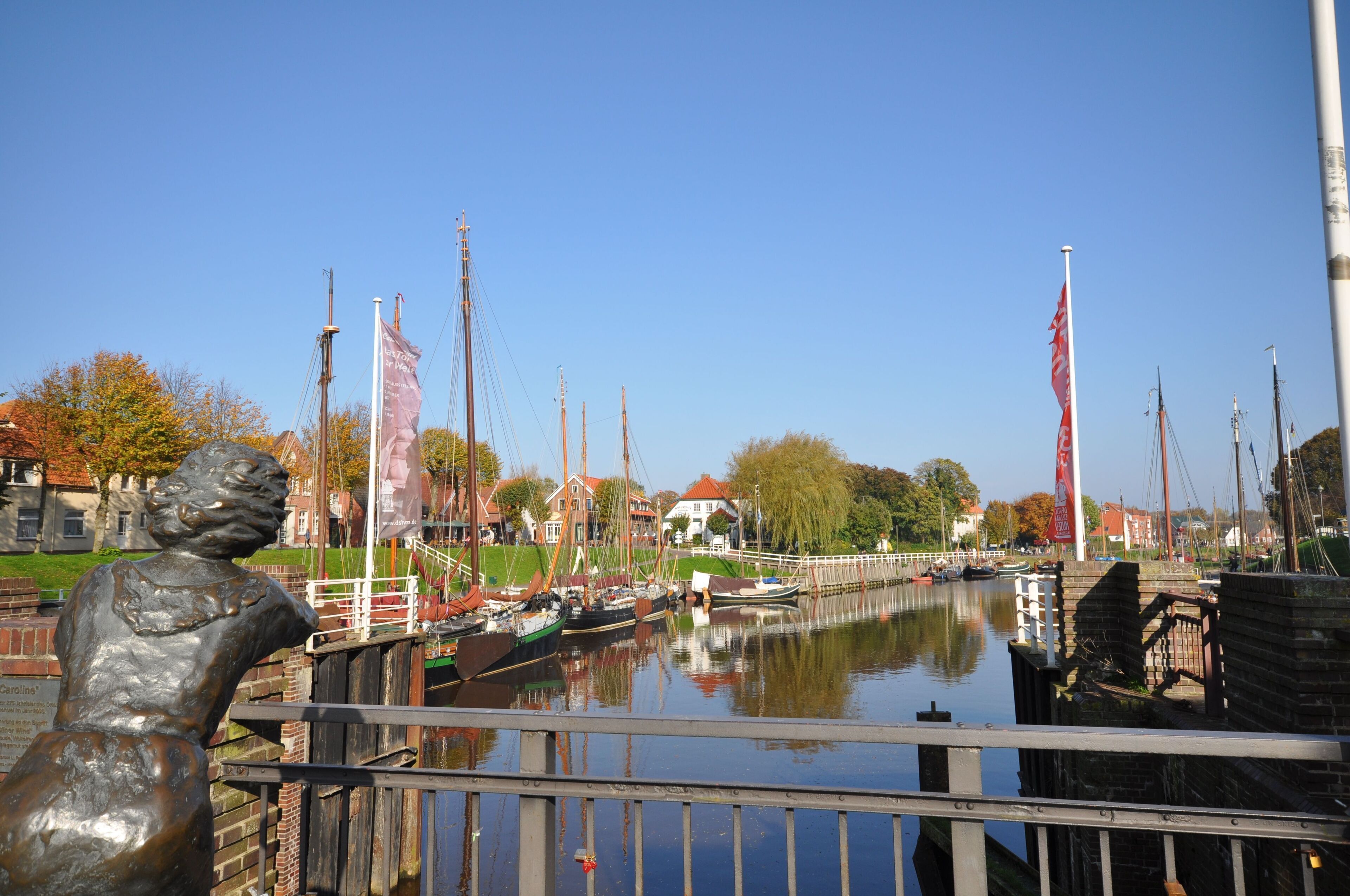 Un canal con barcos, una estatua y edificios al fondo.