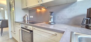 A modern kitchen with stainless steel appliances, a built-in oven, and a coffee maker.