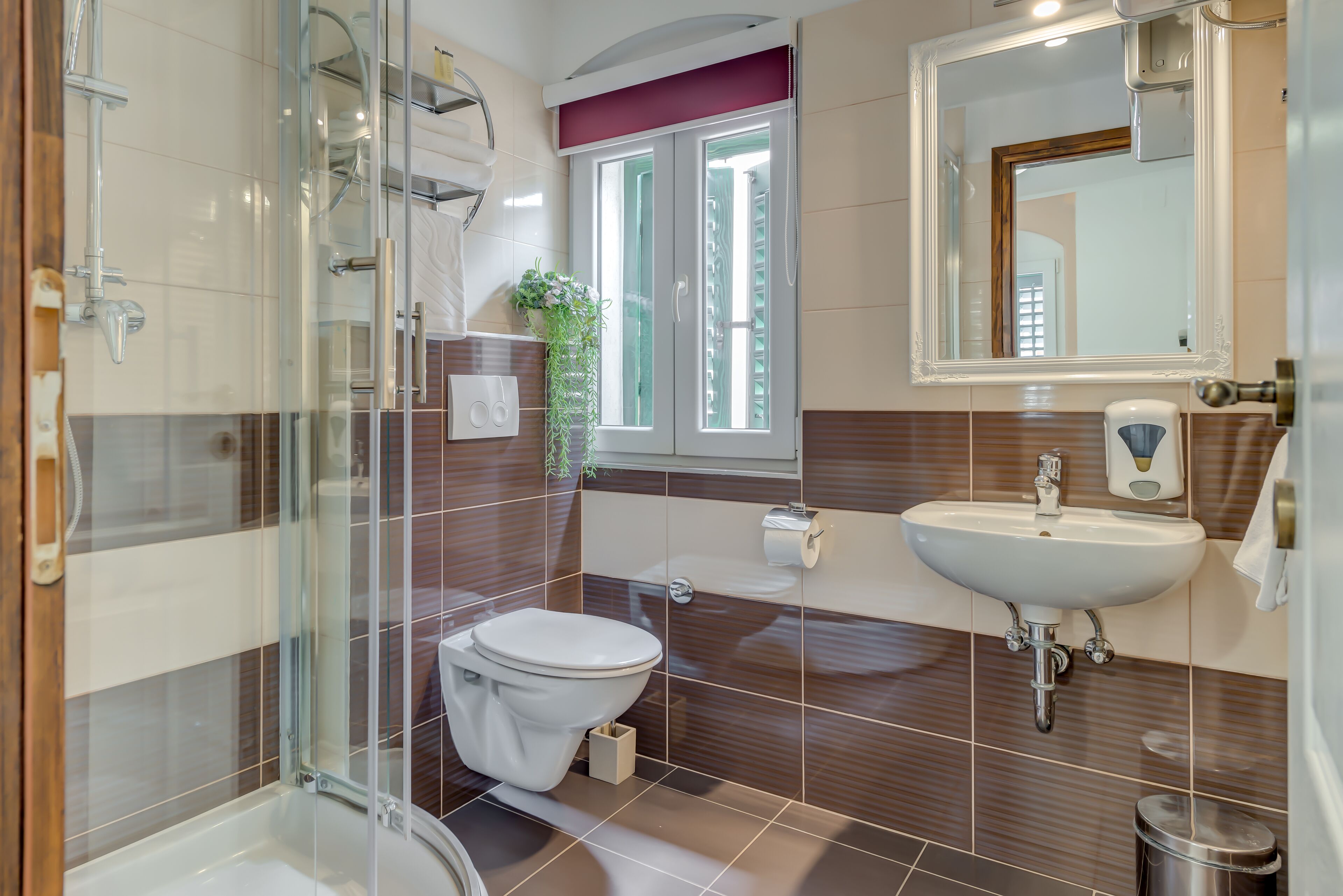 Ein Badezimmer mit einer Duschkabine, einem weißen Waschbecken und einer Toilette.