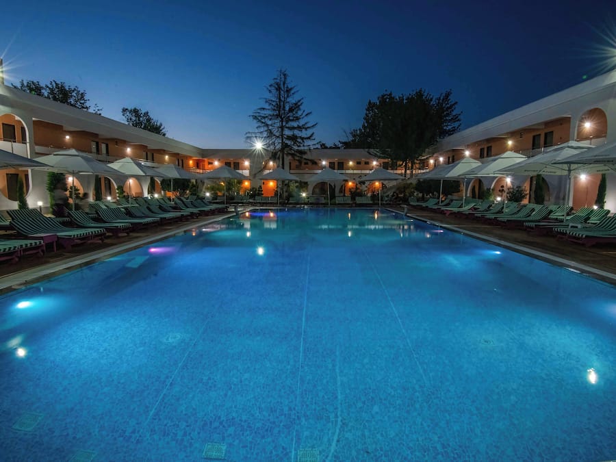 Een buitenzwembad, een zwembad met een waterval