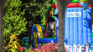 Un área de juegos inflable y colorida con un tobogán y una estructura inflable azul con el rótulo 