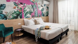 Un dormitorio con una cama, una silla, una mesita y un mural en la pared.