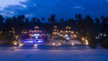 Vista frontal de la propiedad por la tarde o noche