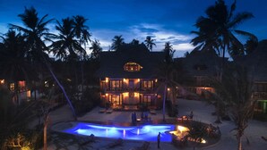 A resort with a pool, lounge area, and multiple buildings with thatched roofs. - Zanziblue (Matemwe)