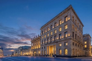 A large, historic building with multiple floors, large windows, and a prominent entrance.