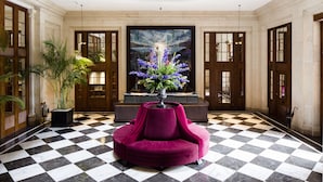 A lobby with a checkered floor, a central seating area, and a large painting on the back wall. - The Edinburgh Grand, a Luxury Collection Hotel, Edinburgh (Edinburgh)
