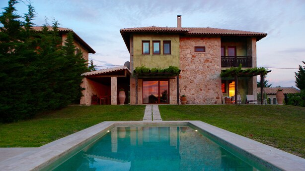 A two-story stone house with a swimming pool in front. - Fruit Garden Villa (Kassandra)