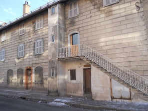 Ein mehrstöckiges Gebäude mit einer Treppe, die zu einem Balkon führt.