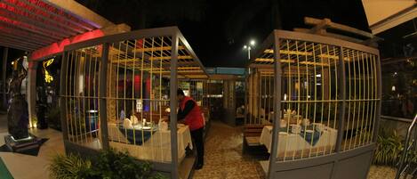 A restaurant with glass enclosures, a tiled floor, and a person working at a counter.